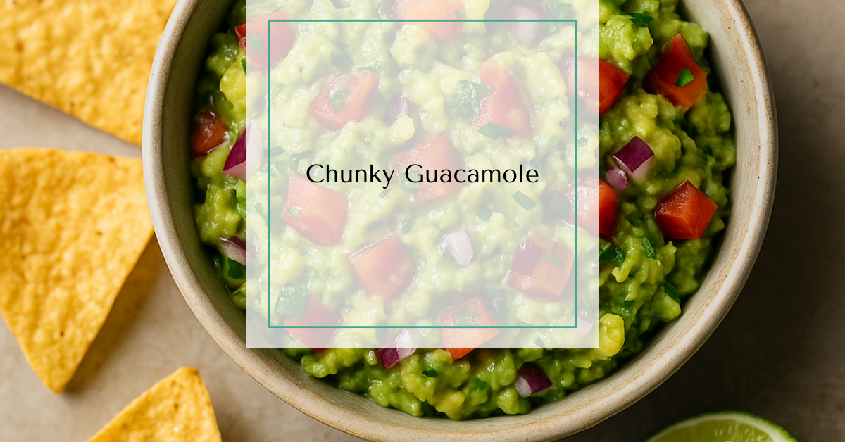 A rustic bowl of chunky guacamole surrounded by lime wedges, tortilla chips, and fresh cilantro