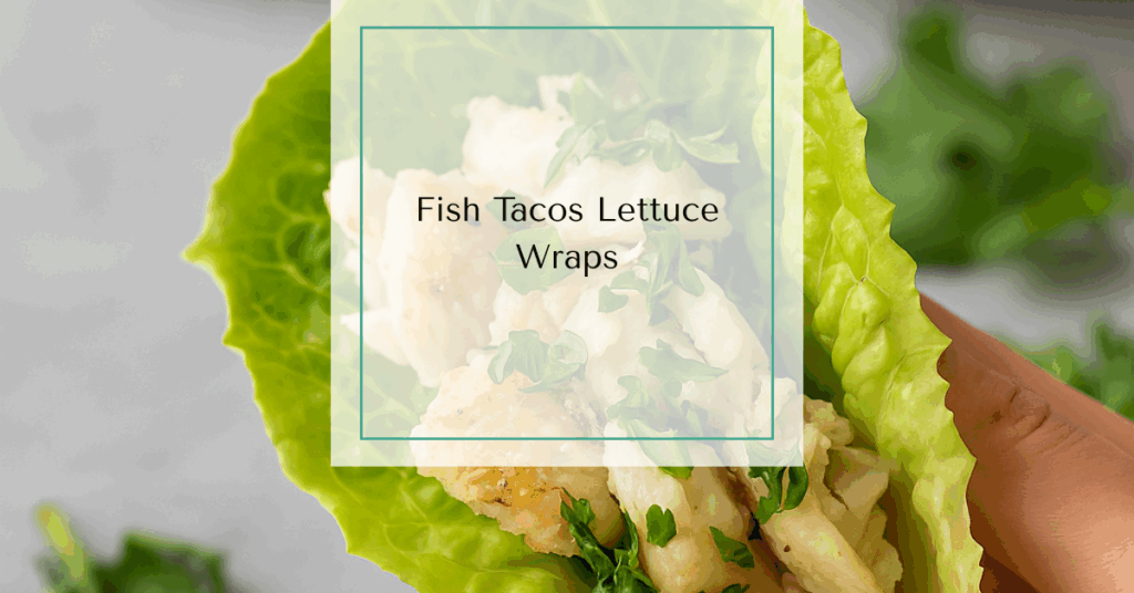 A lettuce-wrapped fish taco filled with flaky white fish and fresh herbs, held in hand over a table.