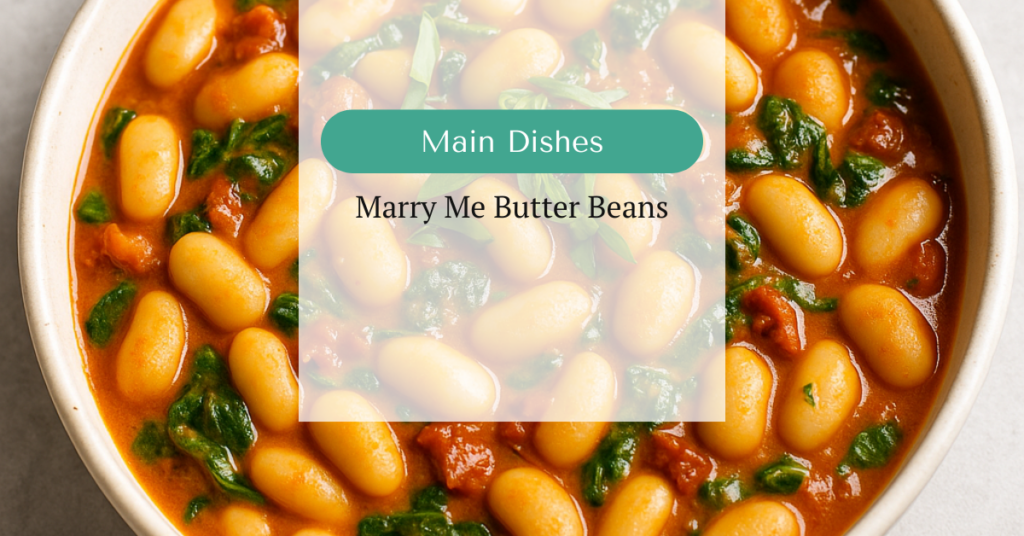 Creamy butter beans in a tomato-based sauce with wilted spinach, sun-dried tomatoes, and fresh basil in a white ceramic bowl.
