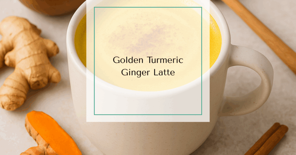 A warm mug of golden turmeric ginger latte with frothy almond milk, topped with a sprinkle of cinnamon and surrounded by fresh turmeric, ginger, and a honey dipper.