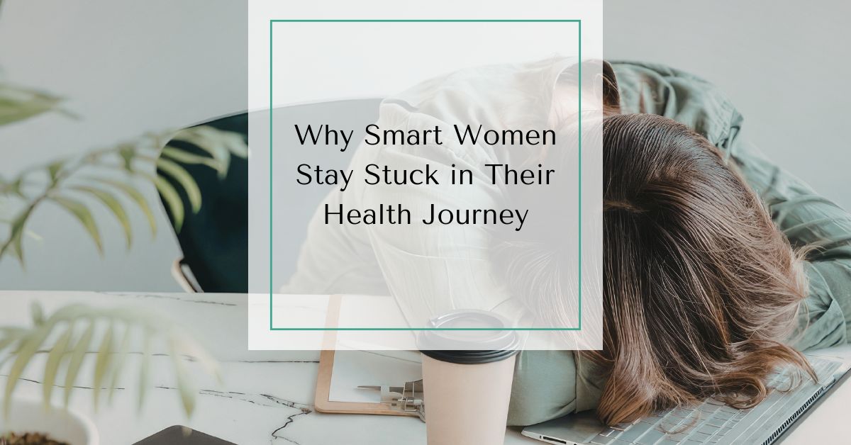 Woman resting her head on a desk beside a laptop and coffee cup with text overlay reading “Why Smart Women Stay Stuck in Their Health Journey.”