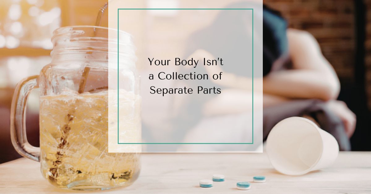 Glass of iced drink, scattered pills, and a woman resting in the background with text overlay reading “Your Body Isn’t a Collection of Separate Parts.”